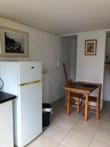 een keuken met een witte koelkast en een tafel bij Appartement lumineux et calme in Jodoigne