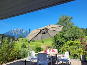 a patio with a table and chairs and an umbrella at Villa Castagna Guesthouse in Lucerne