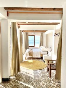 ein Schlafzimmer mit einem Bett und einem großen Fenster in der Unterkunft Zanzibar Tiny Villa at La Villa De Victor in Matemwe