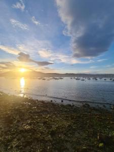 una puesta de sol sobre un cuerpo de agua con barcos en Le pied-à-terre hendayais, en Hendaya