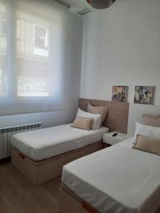 1 dormitorio con 2 camas y ventana en josemaenea, en Pamplona