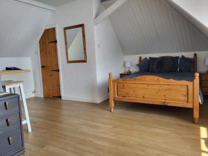 a bedroom with a wooden bed with blue pillows at Seasidesteps in Fishguard