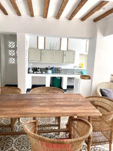 a kitchen and dining room with a wooden table and chairs at Zanzibar Tiny Villa at La Villa De Victor in Matemwe