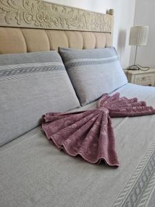 uma cama com um cobertor roxo em cima em LA QUIETE TRA LE VIGNE Tuscany em Collesalvetti