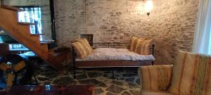 ein Schlafzimmer mit einem Bett und einer Steinmauer in der Unterkunft Domaine Le Mayne in Chabrignac