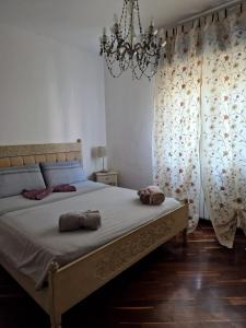 a bedroom with a bed with a chandelier and curtains at LA QUIETE TRA LE VIGNE Tuscany in Collesalvetti