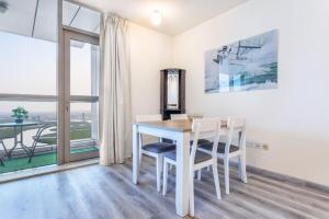 拉斯阿尔卡麦Live in the center of Sea, Mountains, Mangroves of RAK的一间有桌子、椅子和窗户的餐厅