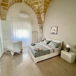 una camera con letto e muro di mattoni di Perla dei Messapi a San Pietro in Bevagna