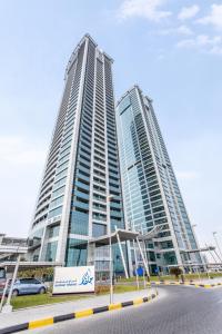 拉斯阿尔卡麦Live in the center of Sea, Mountains, Mangroves of RAK的两座高楼,前面有一辆汽车