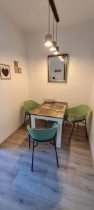 a table and two green chairs in a room at Ferienwohnung Veit in Essen