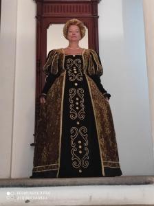 een vrouw in een zwarte en gouden jurk bij Residence Via Benamati in Cagli