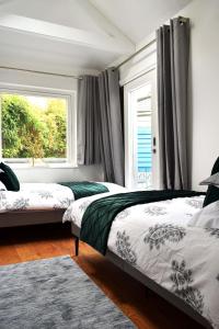 a bedroom with two beds and a window at Cockleshell Cottage in Falmouth