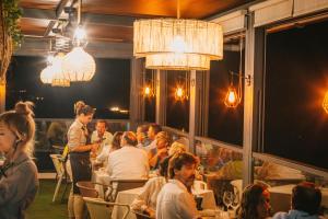 un grupo de personas sentadas en mesas en un restaurante en Hotel Boutique Aroma de Mar, en Chiclana de la Frontera