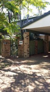 a house with a gate and a brick fence at Baringa Bed & Breakfast in Redcliffe