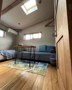 a room with a couch and a table on a rug at CANOA GUEST HOUSE B room- Vacation STAY 47218v in Ikeda