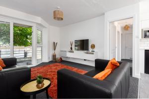 ein Wohnzimmer mit zwei schwarzen Sofas und einem roten Teppich in der Unterkunft Princes - 2 Bedrooms Parking Wi-Fi - Cozy Pads in Preston