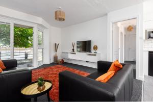 a living room with two black couches and a red rug at Princes - 2 Bedrooms Parking Wi-Fi - Cozy Pads in Preston