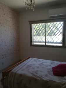 1 dormitorio con cama y ventana en Golden sunshine, en Paralimni