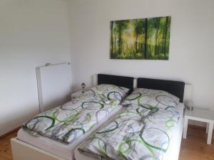 Bett in einem Schlafzimmer mit Wandgemälde in der Unterkunft Ferienwohnung BeLu in Velden am Wörthersee