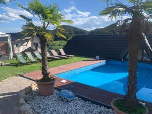 Una piscina con dos palmeras en un patio. en Motel Heaven, en Zgornje Dobrenje 10 fotos más