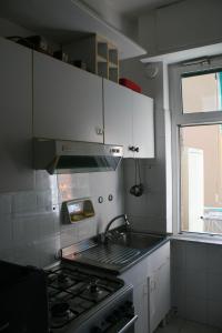 eine Küche mit einem Herd, einem Waschbecken und einem Fenster in der Unterkunft Casa Paggi in Lavagna