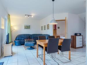 een woonkamer met een tafel en een blauwe bank bij Ferienhaus Zander im Ferienpark Lenzer Höh in Funfseen