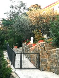 a fence with a cat on top of a stone wall at Tunia in Strunjan