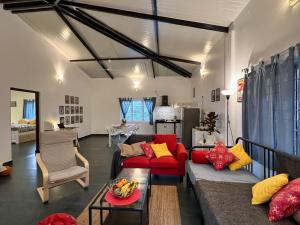 a living room with a red couch and a red chair at Kiki Villa in Arambol