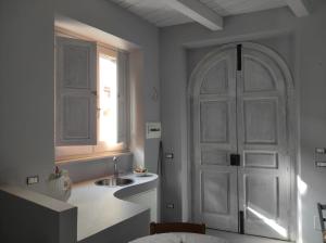 San Lorenzo BellizziにあるFantastica casa ai piedi del Monte Pollinoの白いドアとシンク付きのキッチン