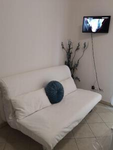 ein weißes Sofa mit einem blauen Kissen darauf in der Unterkunft Corso Umberto Apartment in Soverato Marina