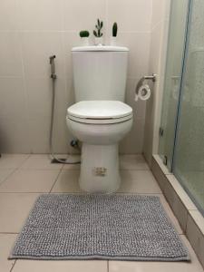 a bathroom with a toilet with a shower and a rug at 1 BR Cozy Modern-Style Condo with Balcony & 5-star amenities at Wind Residences in Tagaytay