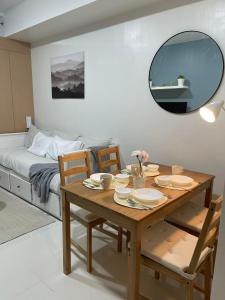 - une salle à manger avec une table, des chaises et un lit dans l'établissement 1 BR Cozy Modern-Style Condo with Balcony & 5-star amenities at Wind Residences, à Tagaytay 100 autres photos