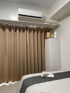 - une chambre avec un lit et la climatisation au plafond dans l'établissement 1 BR Cozy Modern-Style Condo with Balcony & 5-star amenities at Wind Residences, à Tagaytay