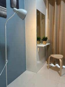 une chambre avec une lampe, une table et un tabouret dans l'établissement 1 BR Cozy Modern-Style Condo with Balcony & 5-star amenities at Wind Residences, à Tagaytay