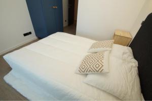 ein weißes Bett mit zwei Kissen darüber in der Unterkunft Label OR appartement spacieux proximité pistes in Les Deux Alpes