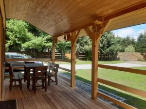 una terraza de madera con mesa y sillas. en Domek na Pętli, en Hoczew