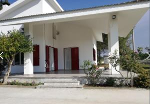 une maison blanche avec des portes rouges et des escaliers. dans l'établissement Villa CAPOROTONDO, à Pisticci