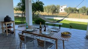 einen Tisch mit Stühlen und eine Hängematte auf der Terrasse in der Unterkunft Villa CAPOROTONDO in Pisticci