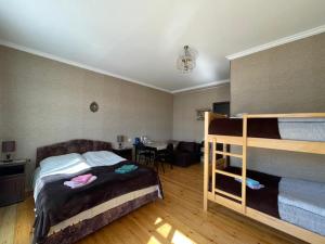 a bedroom with a bunk bed and a desk at Family Hotel 7 Sisters in Stepantsminda