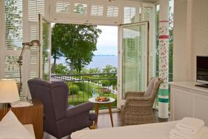 a room with a bed and a view of the ocean at Panorama Hotel Lohme in Lohme