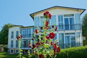 una casa con flores rojas delante de ella en Panorama Hotel Lohme, en Lohme