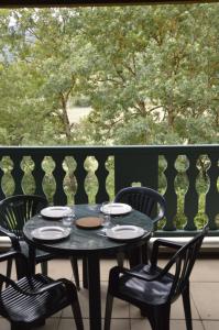 una mesa negra y sillas en el balcón en Studio Confortable Au Coeur d'Arreau, en Arreau