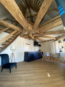una sala de estar con techos y muebles de madera. en Ferme de Mesangeon, en Beauvilliers