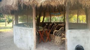 Cabaña pequeña con mesa y sillas en Blue Waxbill Lodge, en Namzunga