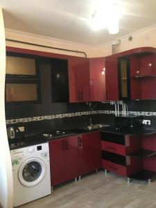 een keuken met rode kasten en een wasmachine bij Драхтик in Jerevan