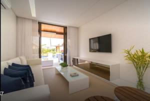 a living room with a couch and a tv at Bangalo Malawi em Muro Alto PE in Porto De Galinhas