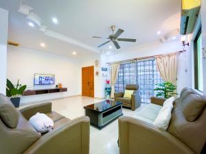 ein Wohnzimmer mit 2 Sofas und einem TV in der Unterkunft Tupai Mas Semi-D by LOUIS in Taiping
