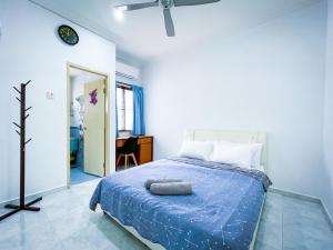- une chambre avec un lit et une couette bleue dans l'établissement Tupai Mas Semi-D by LOUIS, à Taiping