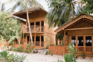atropical house with a balcony and palm trees at Ecoboo Maldives in Thinadhoo