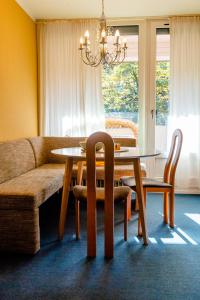 a dining room with a table and chairs and a couch at Gemütl. Wohnung zw. Lüneburger Heide und Hamburg in Buchholz in der Nordheide
